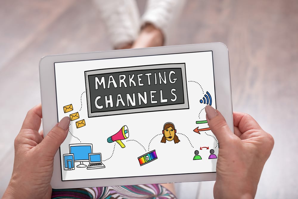 hands holding a tablet with marketing channels displayed on it
